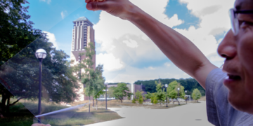 Jay Guo holds a sheet of flexible transparent conductor on the University of Michigan’s College of Engineering North Campus. Credits: Robert Coelius/Michigan Engineering.