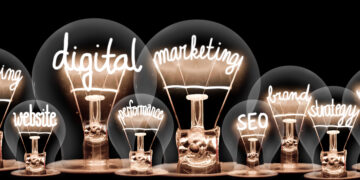 Photo of light bulbs with shining fibers in a shape of Digital Marketing, Website, SEO and Strategy concept related words isolated on black background