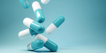 A group of antibiotic pill capsules fallling. Healthcare and medical 3D illustration background.